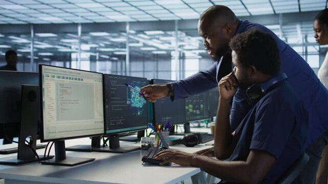 Data center manager helps intern implement AI predictive maintenance systems. Server farm supervisor checks work done by employee using artificial intelligence to identify hardware failures, camera A
