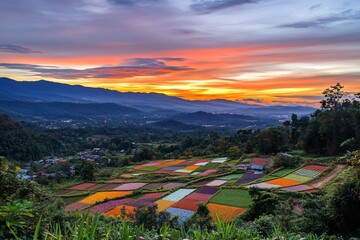 A colorful landscape at sunset, showcasing vibrant fields and distant mountains.