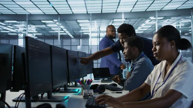 Manager supervising server room workers developing disaster recovery plans ensuring minimal downtime. Supervisor oversees data center technicians using data analytics to monitor performance, camera A