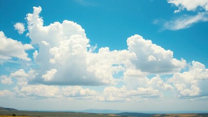Obraz premium Large White Clouds Drifting Across a Clear Blue Sky, Providing Shade From the Sun's Rays