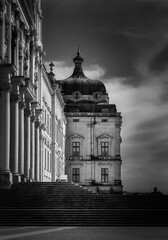 Dramatic black and white photography showcasing the grandeur of mafra national palace, highlighting its architectural details and imposing presence under a cloudy sky in lisbon, portugal