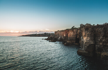 The warm hues of sunset paint the sky as the rugged cliffs of boca do inferno meet the vast expanse...