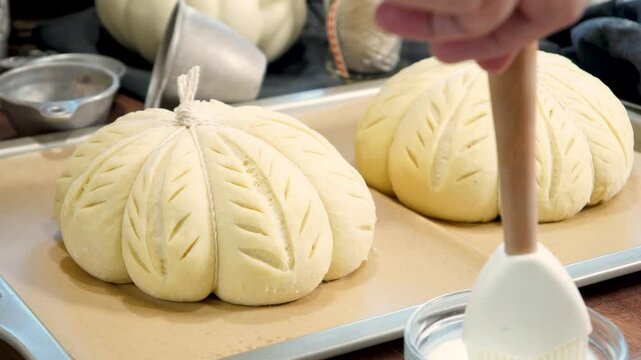 Baking pumpkin bread for family and friends for Thanksgiving dinner.  An Autumn favorite,  pumpkin shaped bread with decorative scoring complete with a cinnamon stick.