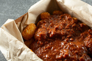 A closeup view of a container of chili tots.