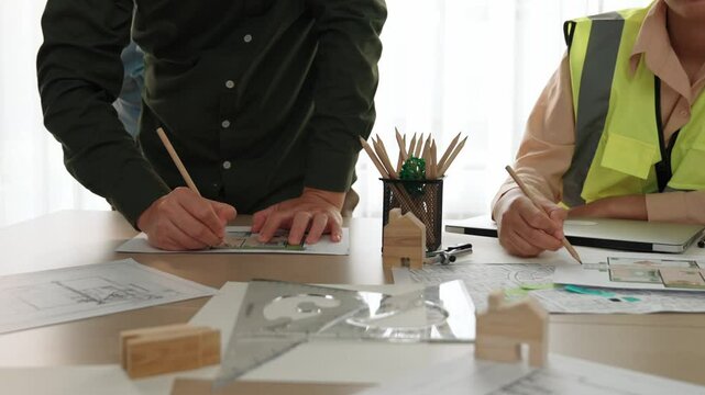 Professional engineer measuring the blueprint. Professional engineer working architectural project at studio on a table with yellow helmet and architectural equipment scatter around. Delineation.