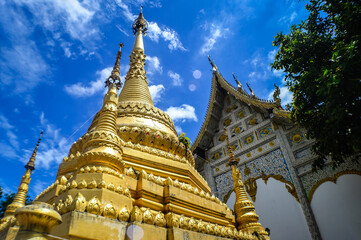 Fototapeta premium Chapel and Gold Pagoda, Lanna Architecture, Symbols of Buddhism, South East Asia at Ko Klang temple, Muang Chiang Mai, Chiang Mai, Northern Thailand