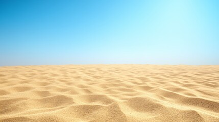 A wide, open shot of a sandy beach with clear blue skies.