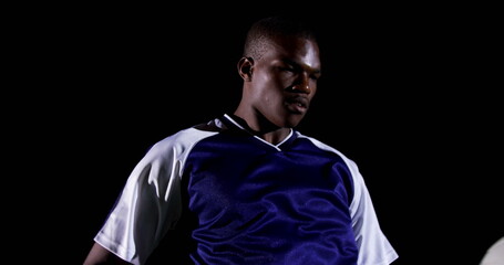 Confident soccer player juggling ball on playing field