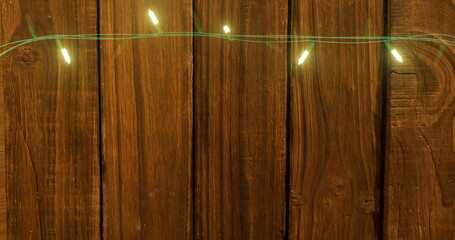 Image of flickering fairy lights with copy space on wooden background - Powered by Adobe