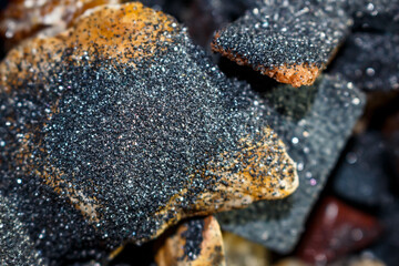 Silicon carbide powder on stones, abrasive grinding powder glitters on stones in tumbling drum