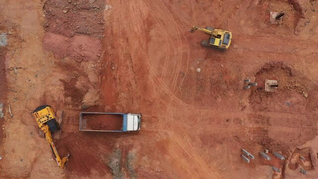 Aerial view road motor grader flatting dirt road surface, Motor grader road construction grader industrial machine construction site new road, Aerial view group excavator working on construction site.