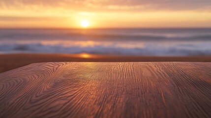 Fototapeta premium 6.A wooden table top with visible grain patterns in sharp focus, set against the blurred backdrop of a beach at sunset. The horizon glows with warm orange and pink hues, while gentle waves roll in,