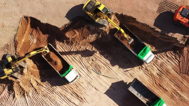 Aerial view road motor grader flatting dirt road surface, Motor grader road construction grader industrial machine construction site new road, Aerial view group excavator working on construction site.