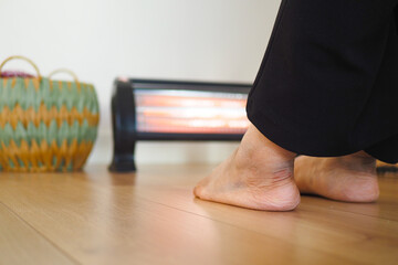 Cozy Home Scene With Feet Warming Near Electric Heater