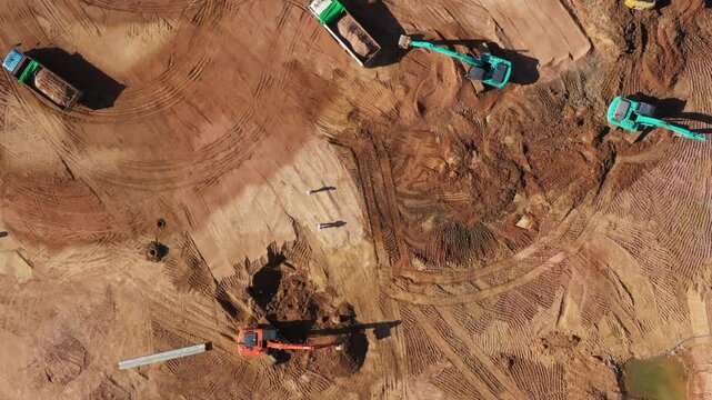 Aerial view road motor grader flatting dirt road surface, Motor grader road construction grader industrial machine construction site new road, Aerial view group excavator working on construction site.