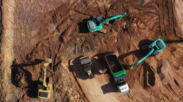Aerial view road motor grader flatting dirt road surface, Motor grader road construction grader industrial machine construction site new road, Aerial view group excavator working on construction site.