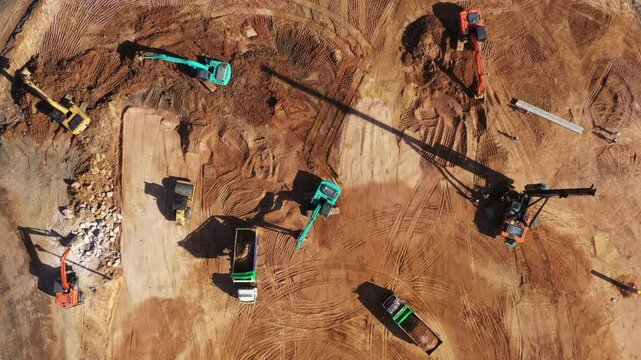 Aerial view road motor grader flatting dirt road surface, Motor grader road construction grader industrial machine construction site new road, Aerial view group excavator working on construction site.
