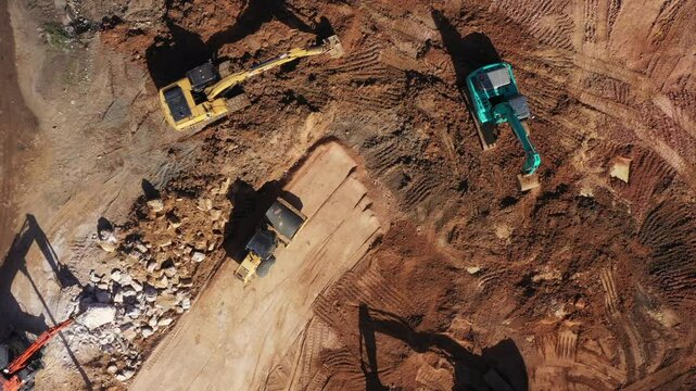 Aerial view road motor grader flatting dirt road surface, Motor grader road construction grader industrial machine construction site new road, Aerial view group excavator working on construction site.