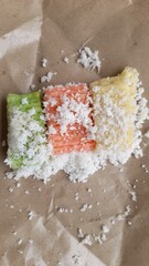getuk lindri made from cassava with sugar and grated coconut on rice paper background. Getuk Lindri comes from Magelang, East Java. the concept of traditional snacks, old, snacks, culinary, symbol