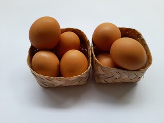 Raw chicken eggs in a woven basket. livestock background concept, food packaging, chicken egg shop, traditional market, protein sources, agricultural products, breakfast, lunch, cooking ingredients