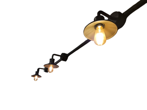 Row of industrial style wall lamps with black wiring and armatures, glowing warmly with golden light, creating a bold and stylish ambiance on a transparent or white background