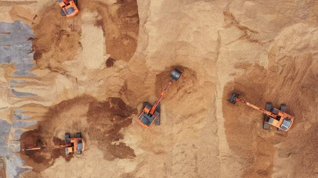 Aerial view road motor grader flatting dirt road surface, Motor grader road construction grader industrial machine construction site new road, Aerial view group excavator working on construction site.