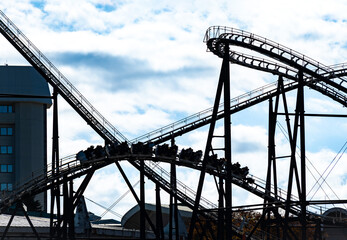 遊園地のアトラクションジェットコースターとよく晴れた日の空