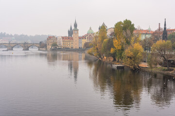 Vltava River on a foggy day overlooking Charles Bridge and medieval buildings, Prague.