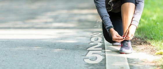 The start into the new year 2025. Start up of runner woman running on nature race track go to Goal...