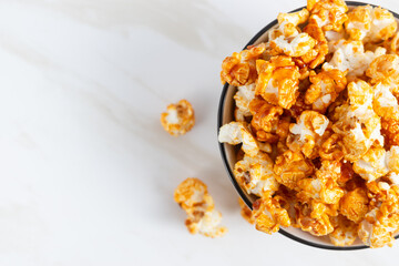 caramel popcorn in a white bowl. Perfect for recipe, article, catalogue, or any commercial purposes. with copy space.