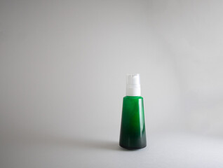 A green spray bottle with a white pump cap, isolated against a neutral background. Ideal for cosmetic, skincare, or household product presentations.