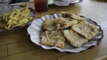 a plate of fried tempeh or mendoan, a typical Indonesian food made from soybeans, served with other...