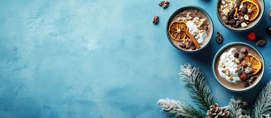 Cozy homemade hot cocoa with cream, dried oranges, nuts, and festive decor on a blue backdrop perfect for winter celebrations