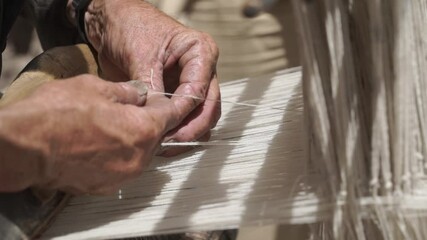 A skilled craftsman weaves a traditional wool fabric on old antique  wooden loom in Ladakh, India - Powered by Adobe
