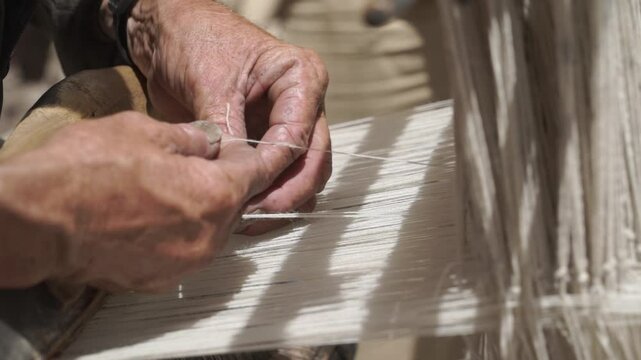 A skilled craftsman weaves a traditional wool fabric on old antique  wooden loom in Ladakh, India