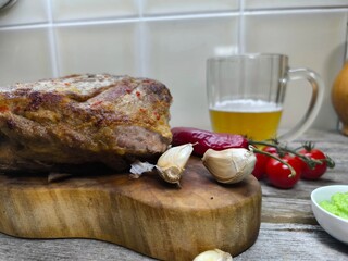 the tenderest fried piece of meat lies on a sliced board. There a glass of beer next to it