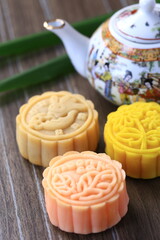 Chinese mid-autumn festival foods. Traditional mooncakes on table setting with teapot 