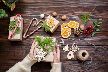 Sustainable christmas. Female hands are packaging christmas gifts craft paper. Eco Christmas holiday concept. Zero waste, eco friendly.