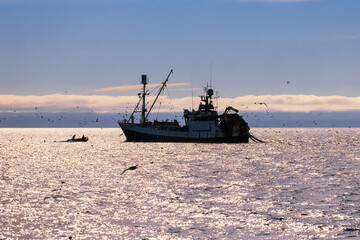 Fishing boat with a trawl on the sea