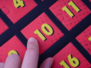 Woman finger ready to open the door with number 10 on the advent calendar.