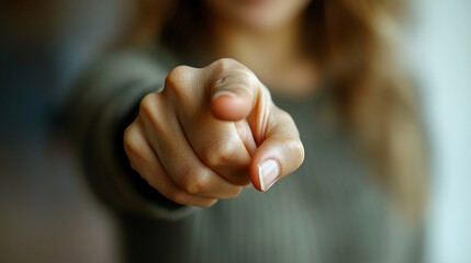 woman’s index finger pointing directly at the viewer conveying confidence, engagement, and a sense of direction with a clean and sharp focus on her gesture