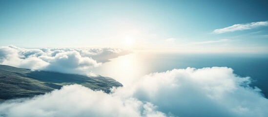 Obraz premium Serene coastal landscape with sunlit clouds above the tranquil sea horizon creating a peaceful and calming atmosphere
