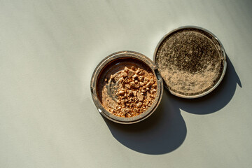 Broken palette with bronzer on a white table. Decorative cosmetics