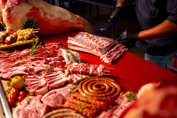 Hand cutting piece of raw pork meat on wooden surface kitchen board. Chef holding knife cuts pork. Steak for barbecue