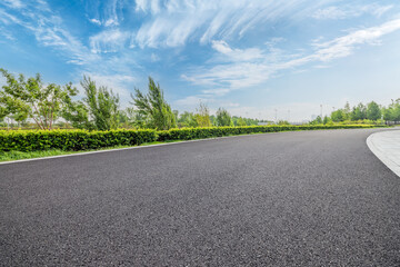 Empty asphalt road with grass and trees