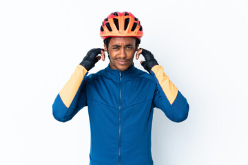 Young cyclist man with braids over isolated background frustrated and covering ears
