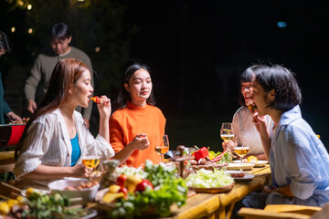 A group of women are sitting around a table eating and drinking