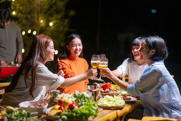 A group of women are gathered around a table with food and drinks