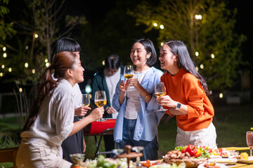 A group of women are laughing and drinking wine at a party