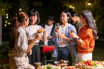 A group of people are gathered around a table with wine glasses and food